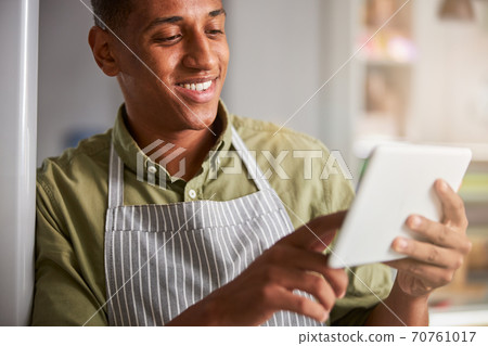 Floral specialist having a great mood while holding a tablet 70761017