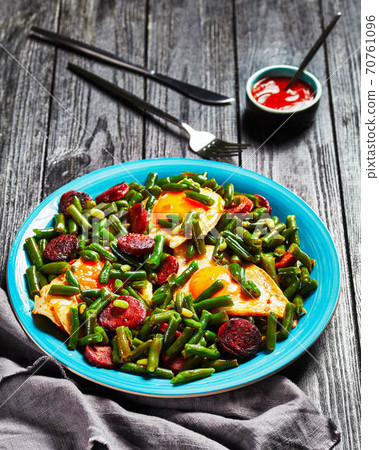 Green beans fried eggs and chorizo on a blue plate Green beans fried eggs and chorizo on a blue plate 70761096