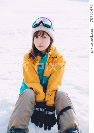A woman who snowboards 70761476