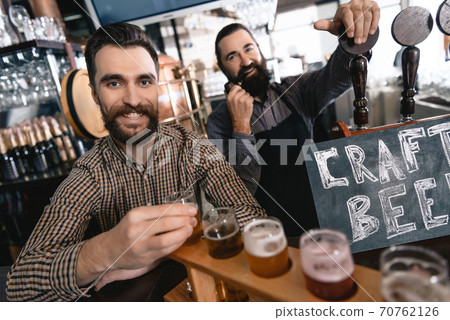 A man smiles while stands near a bar in a brewery 70762126