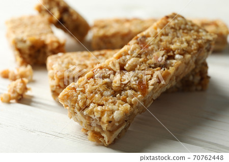 Tasty granola bars on white wooden background Tasty granola bars on white wooden background 70762448