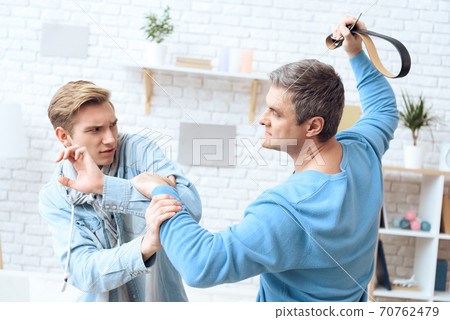 Dad waved his son at home with a belt. Dad waved his son at home with a belt. 70762479