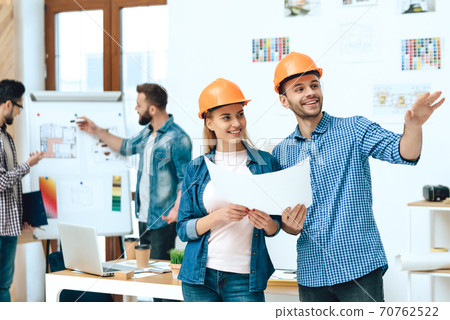 Two designers architects posing with papers. Two designers architects posing with papers. 70762522