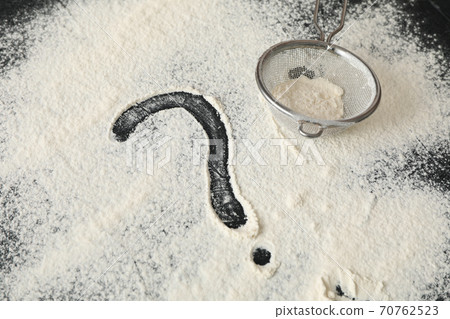 Flour, sieve and question mark on black background Flour, sieve and question mark on black background 70762523