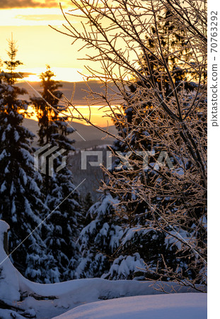 Small and quiet alpine village outskirts and winter sunrise snowy mountains around, Voronenko, Carpathian, Ukraine. 70763292