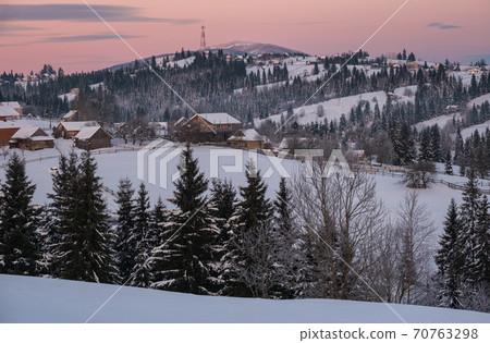 Small and quiet alpine village and winter sunrise snowy mountains around, Voronenko, Carpathian, Ukraine. Small and quiet alpine village and winter sunrise snowy mountains around, Voronenko, Carpathian, Ukraine. 70763298