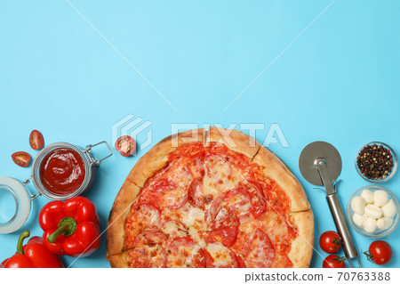 Tasty pizza and ingredients on blue background 70763388
