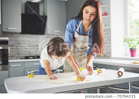 Mom loving the oven for the daughter of the cookie. 70764235