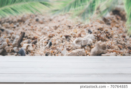 White wooden planks with blur beach on background and  palm leaves on foreground,summer concepts. 70764885