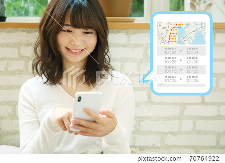 Image of a woman using a map / train app on her smartphone Image of a woman using a map / train app on her smartphone 70764922