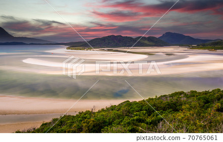Pink clouds at sunrise over Hill Inlet at Whitsunday Island in rare green color 70765061