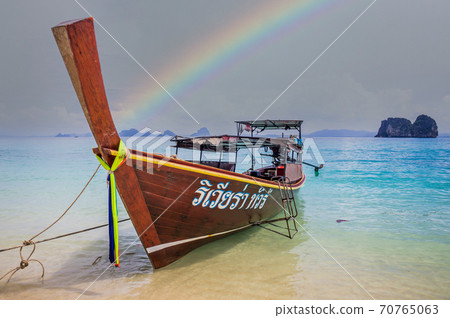 Longtail boat on beach in Thailand with rainbow 70765063