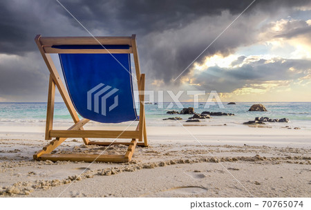 Dark clouds over deck chair at white beach in Ko Lipe, Thailand 70765074