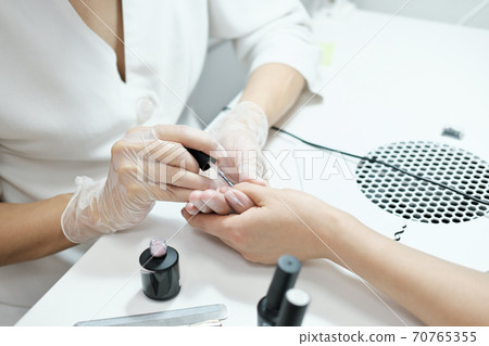 side view of manicurist working in beauty salon 70765355