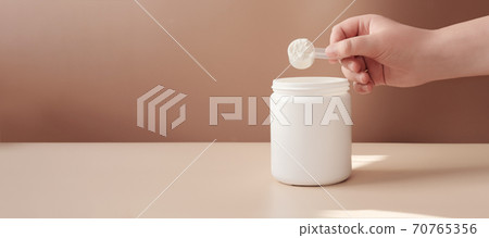 hand holding scoop of fish collagen. banner.copy space.  70765356
