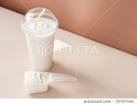 whey protein cocktail in a disposable cup and scoop of collagen 70765560