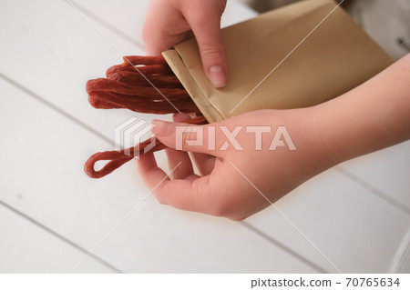 womans hand holding biltong or jerked meat. womans hand holding biltong or jerked meat. 70765634