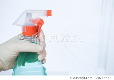 hand holding sprayer with detergent cleaning product. Home cleaning and Housekeeping concept.  70765648