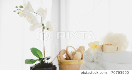 Spa products with white towels,soap,luffa scrub,comb and beautiful orchid flower in clean white room 70765900