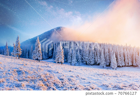 Beautiful winter landscape in the Carpathian mountains. Vibrant night sky with stars and nebula and galaxy. Deep sky astrophoto 70766127