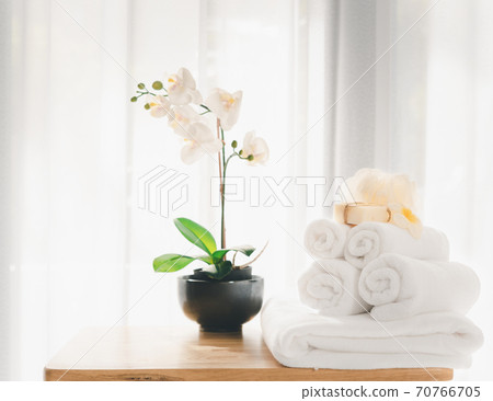 Spa products with white towels,soap,luffa scrub,comb and beautiful orchid flower in clean white room 70766705