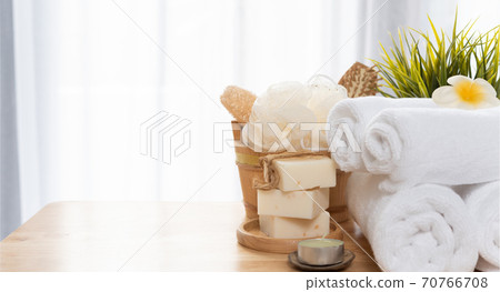 White towels,soap,luffa scrub,comb,candle and beautiful frangipani flower in clean white bathroom 70766708