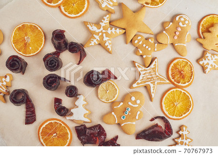Decorating a spicy cookie with white glaze and orange. Happy New Year. 70767973