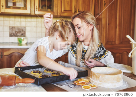 Mom and daughter are busy baking cookies 70768960