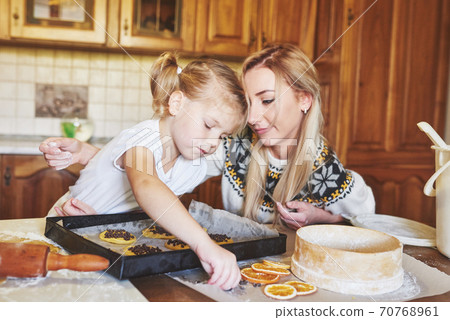 Mom and daughter are busy baking cookies 70768961