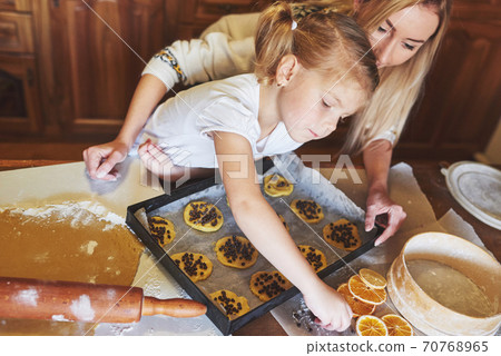 Mom and daughter are busy baking cookies 70768965