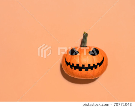 Halloween pumpkin in hand on orange background. 70771048