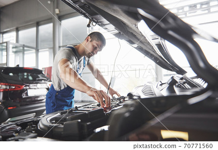 Picture showing muscular car service worker repairing vehicle 70771560