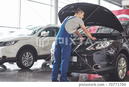 Picture showing muscular car service worker repairing vehicle Picture showing muscular car service worker repairing vehicle 70771700