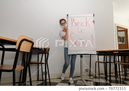 Girl wearing a medical mask in an empty classroom Girl wearing a medical mask in an empty classroom 70772315