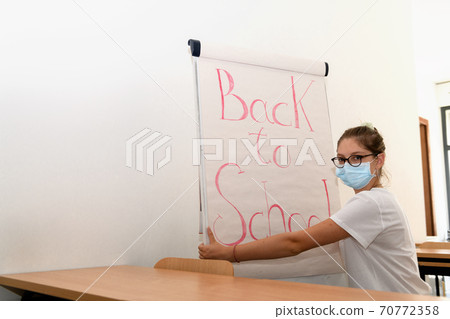Girl writing back to school on whiteboard wearing Girl writing back to school on whiteboard wearing 70772358