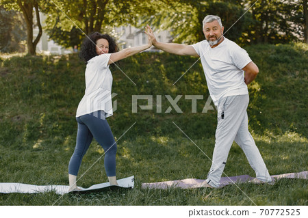 Happy elderly senior couple doing yoga Happy elderly senior couple doing yoga 70772525