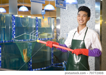 A supermarket seafood salesman with fish high quality photo 70772808