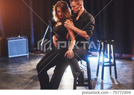 Skillful dancers performing in the dark room under the light 70772809