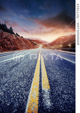 Asphalt road and lonely tree under a starry night sky and the Milky Way Asphalt road and lonely tree under a starry night sky and the Milky Way 70773914