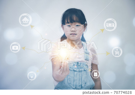 Asian Little girl holding the light bulb in graph Screen Icon of media screen,Technology Process System Business concept. 70774028