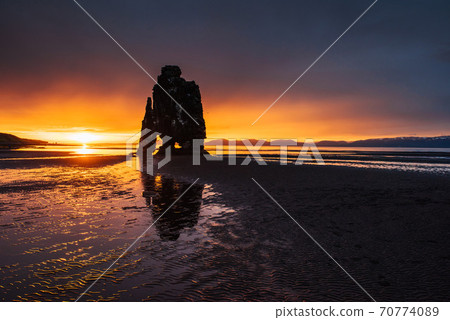 Is a spectacular rock in the sea on the Northern coast of Iceland. Legends say it is a petrified troll. On this photo Hvitserkur reflects in the sea water after the midnight sunset 70774089
