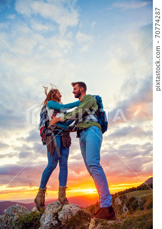 Couple on Top of a Mountain Hugging and enjoying view. Couple on Top of a Mountain Hugging and enjoying view. 70774287