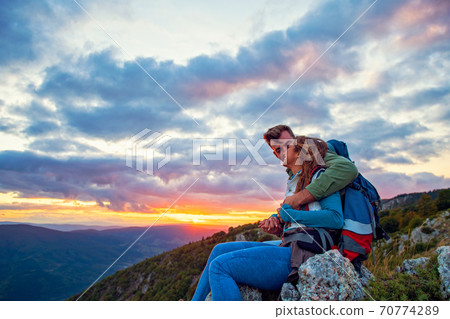 Young Couple Sitting On Top Of Mountain 70774289
