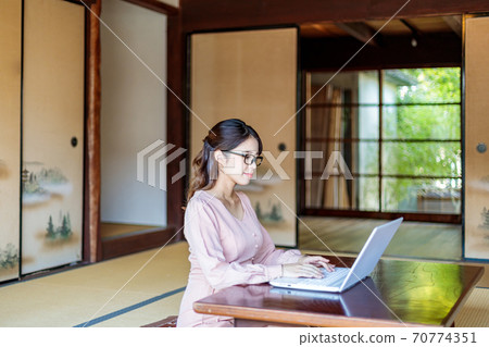 A woman who lives in the country and works using a computer 70774351