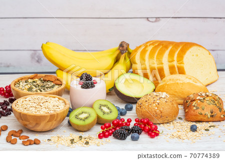 Group Fruits Breakfast with bread Whole grains and nuts, yogurt mix with Cherry , banana, avocado in the wooden table. Breakfast for Health and Diet concept 70774389