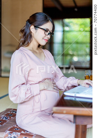 A woman who lives in the country and works using a computer 70774400
