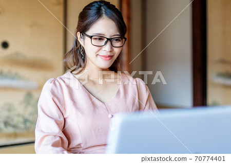 A woman who lives in the country and works using a computer 70774401