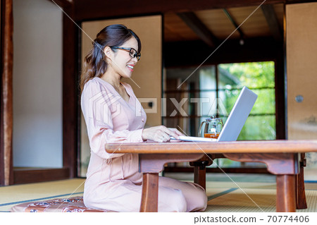 A woman who lives in the country and works using a computer A woman who lives in the country and works using a computer 70774406