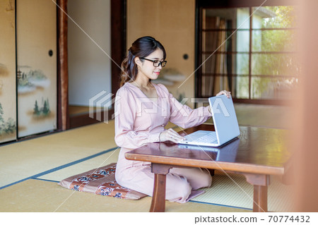 A woman who lives in the country and works using a computer 70774432
