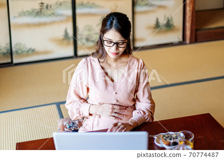 A woman who lives in the country and works using a computer A woman who lives in the country and works using a computer 70774487